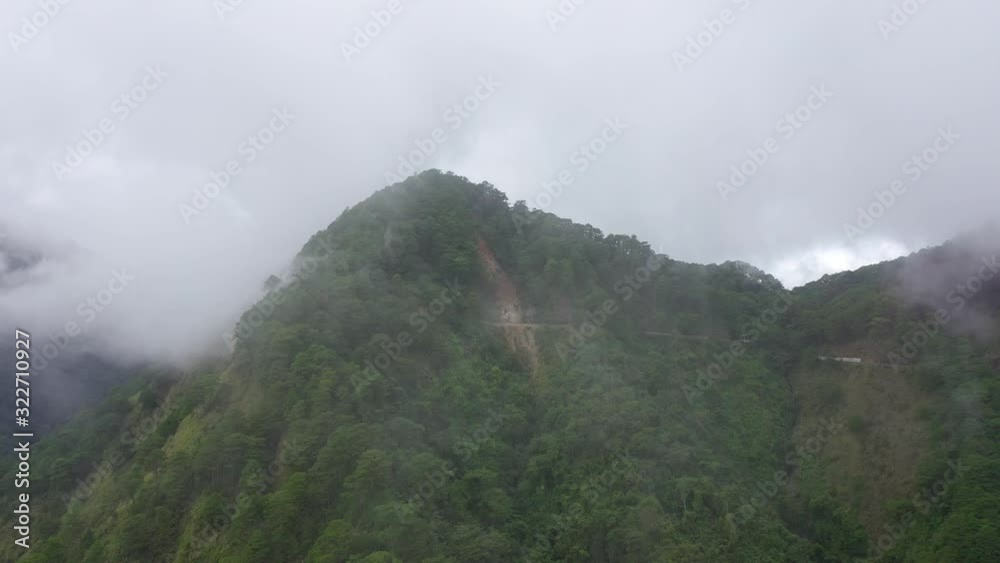 The rainy clouds covered the top of green forest mountain. Cordillera on Luzon Island, Philippines, aerial view. Rain clouds in a tropical climate. The rainy clouds covered the top of green forest mountain. Cordillera on Luzon Island, Philippines, aerial view. Rain clouds in a tropical climate.