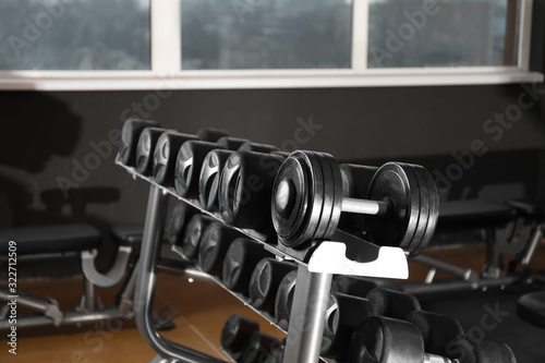 Fototapeta Naklejka Na Ścianę i Meble -  Dumbbells on rack in gym. Modern sport equipment