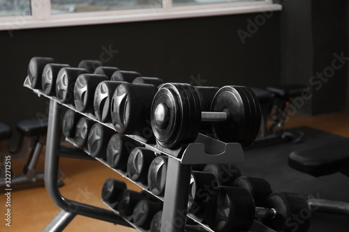 Fototapeta Naklejka Na Ścianę i Meble -  Dumbbells on rack in gym. Modern sport equipment