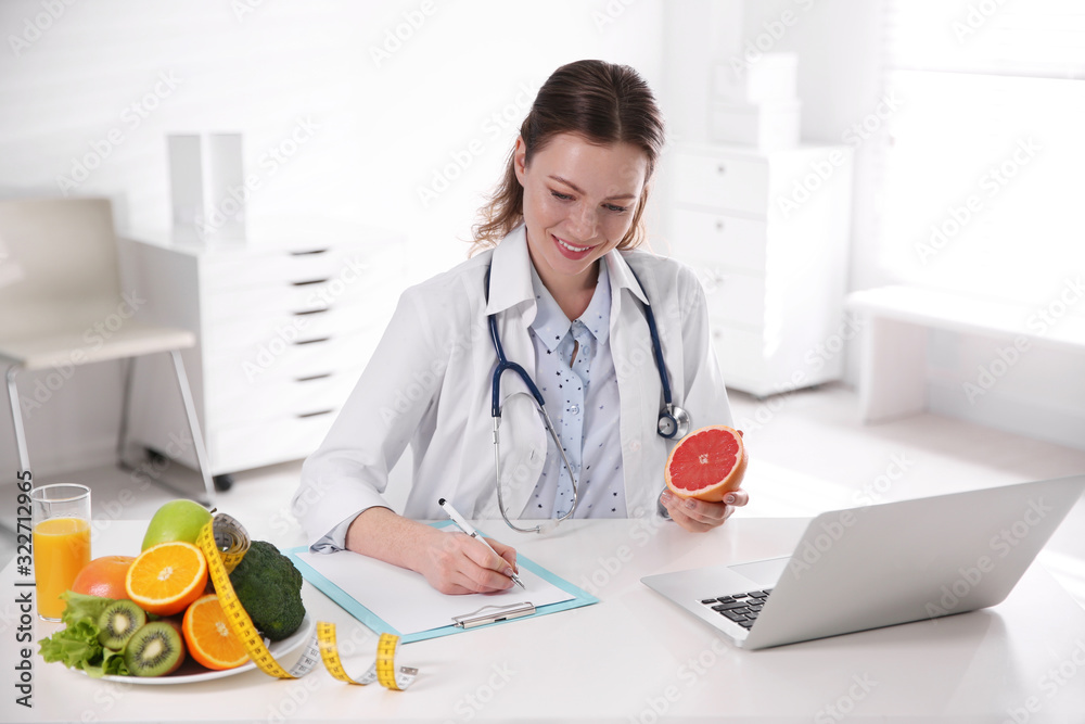 Female nutritionist working at desk in office Female nutritionist working at desk in office