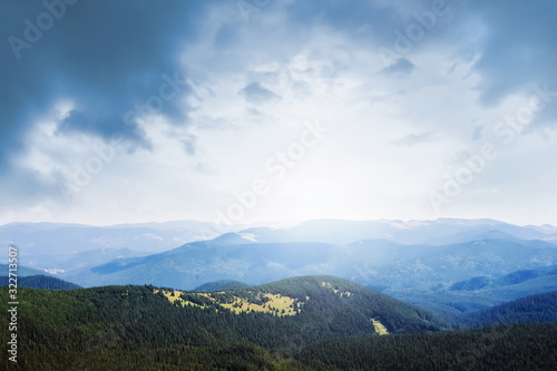 Picturesque mountain landscape with dark clouds and sunlight_