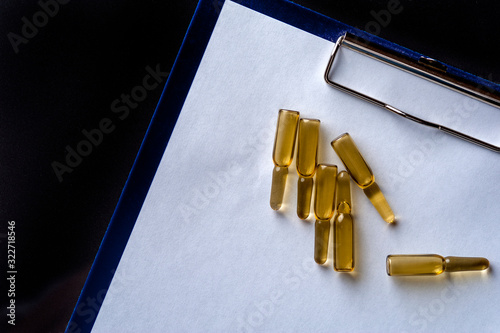 Close-up glass ampoules with medicine on empty sheet