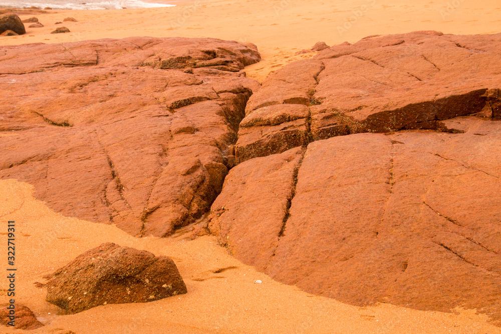 Fototapeta premium Beach Sand and Large Rocks Line the Seashore