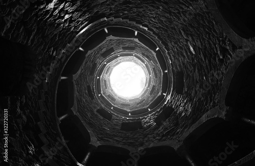 Initiation well, Sintra, Greater Lisbon, Portugal. Scary looking up shot of this really deep well. Similar to a Batman's location. Black and white photograph. Beautiful composition & art.