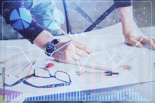 Multi exposure of man standing and planing investment with stock market forex chart.