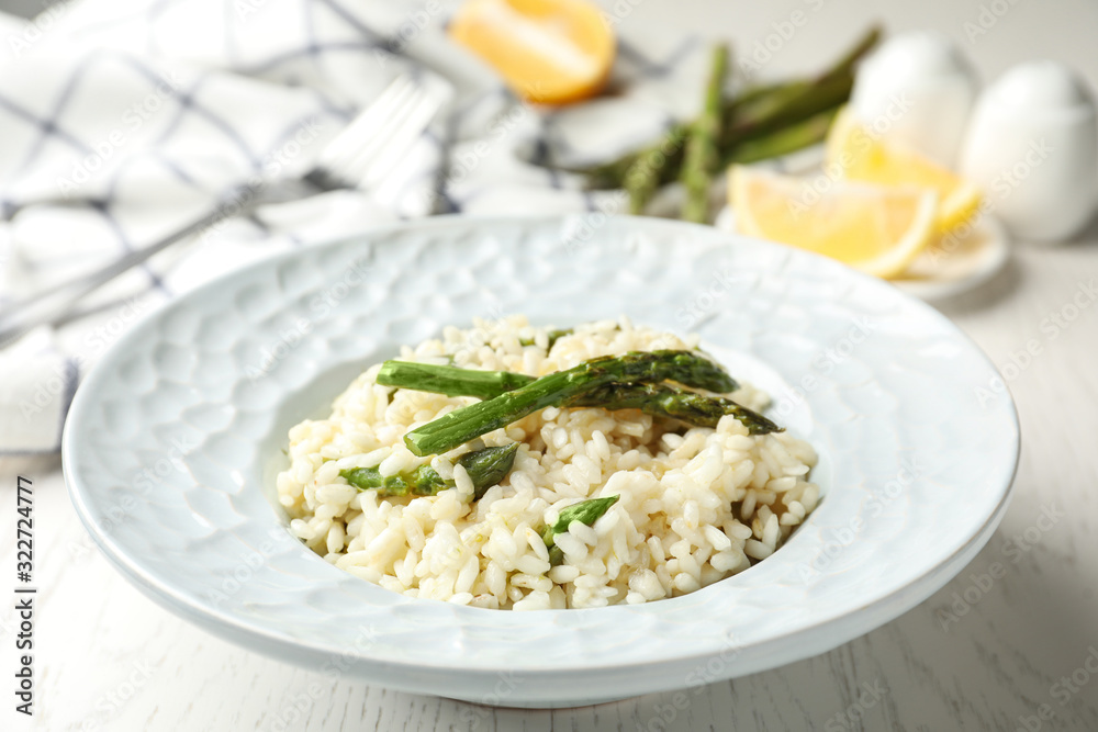 Delicious risotto with asparagus on white wooden table, closeup Delicious risotto with asparagus on white wooden table, closeup