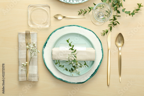 Elegant table setting with flowers and leaves, flat lay