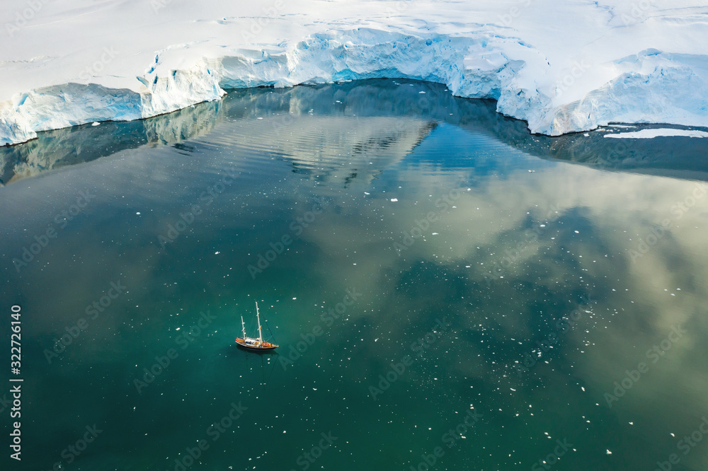 aerial view to yacht in lagoon under huge glacier aerial view to yacht in lagoon under huge glacier