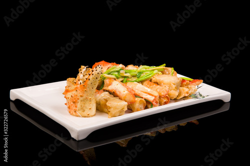 crab legs in a batter with green onions on a black background