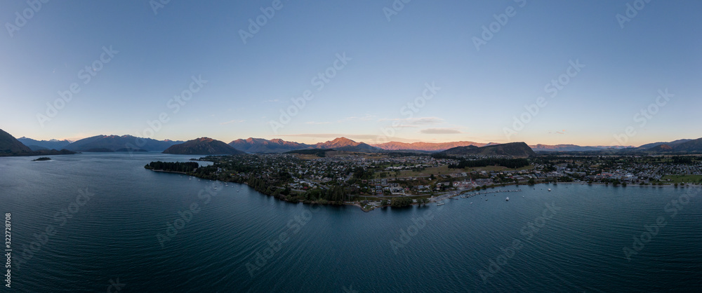XXL panoramic evening sunset high angle aerial drone view of the town of Wanaka, a popular ski and summer resort town located at Lake Wanaka in the Otago region of the South Island of New Zealand.