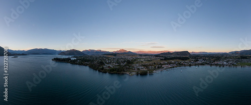 XXL panoramic evening sunset high angle aerial drone view of the town of Wanaka, a popular ski and summer resort town located at Lake Wanaka in the Otago region of the South Island of New Zealand. © Juergen Wallstabe