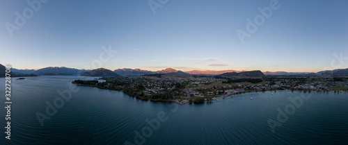 XXL panoramic evening sunset high angle aerial drone view of the town of Wanaka, a popular ski and summer resort town located at Lake Wanaka in the Otago region of the South Island of New Zealand.