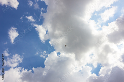 A small aircraft flying under the clouds