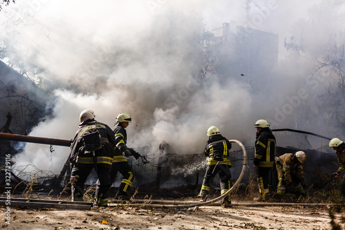 Canvas Print Firefighters in action, fire hoses