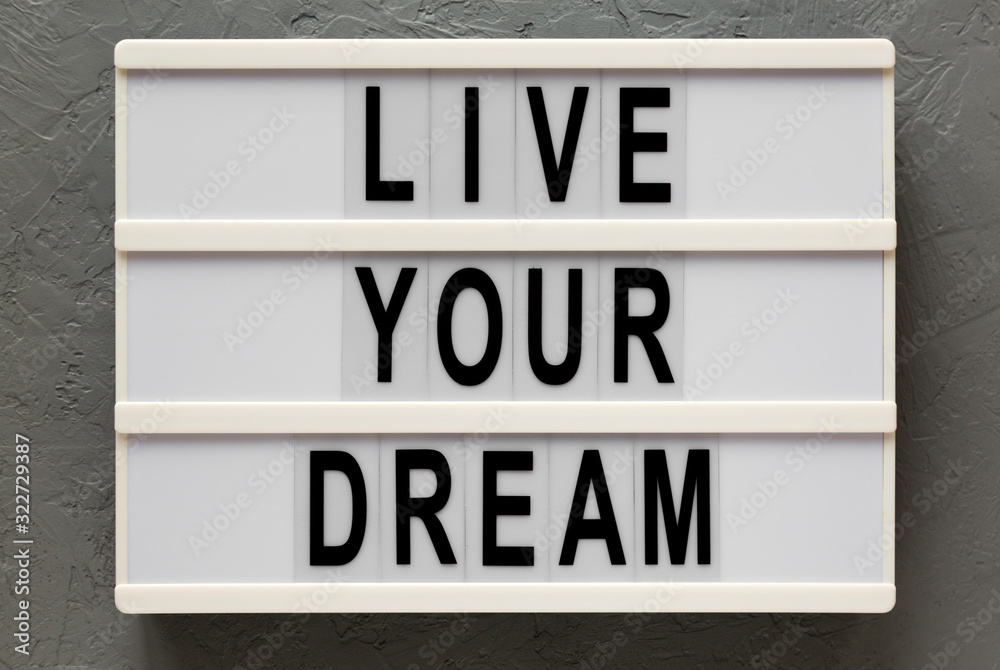 'Live your dream' words on a modern board on a gray background, top view. Overhead, from above, flat lay. 'Live your dream' words on a modern board on a gray background, top view. Overhead, from above, flat lay.