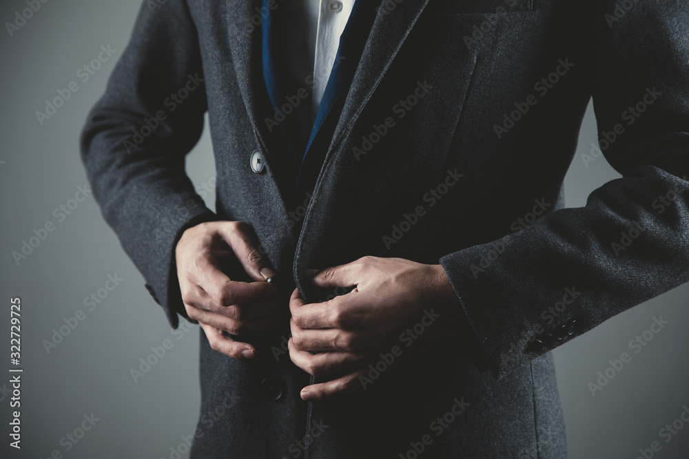 man hand suit button on dark background