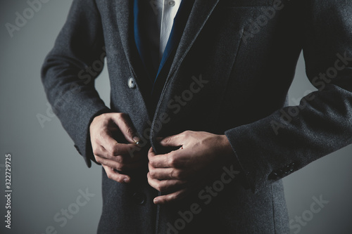man hand suit button on dark background
