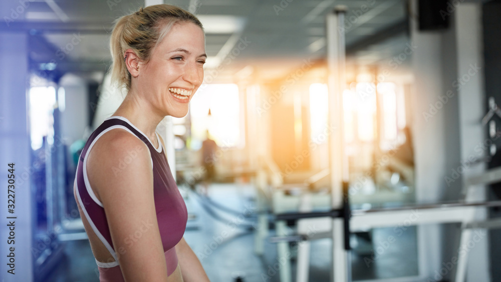 Fototapeta premium Laughing young woman in the fitness center