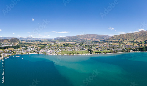 Fototapeta Naklejka Na Ścianę i Meble -  Beautiful panoramic high angle aerial drone view of the town of Wanaka, a popular ski and summer resort town located at Lake Wanaka in the Otago region of the South Island of New Zealand.