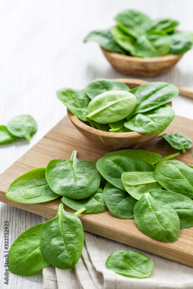 Fresh green leaves spinach on a wooden cutting board Fresh green leaves spinach on a wooden cutting board