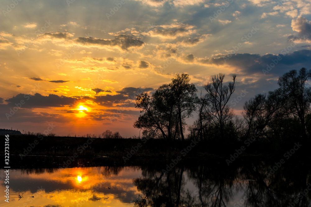 Colorful sunset behind the clouds above the water Colorful sunset behind the clouds above the water