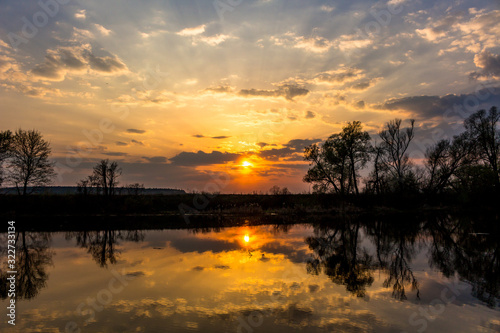 Colorful sunset behind the clouds above the water