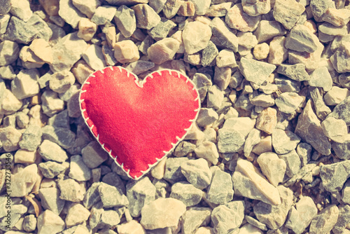 Stitched red heart on a gravel background