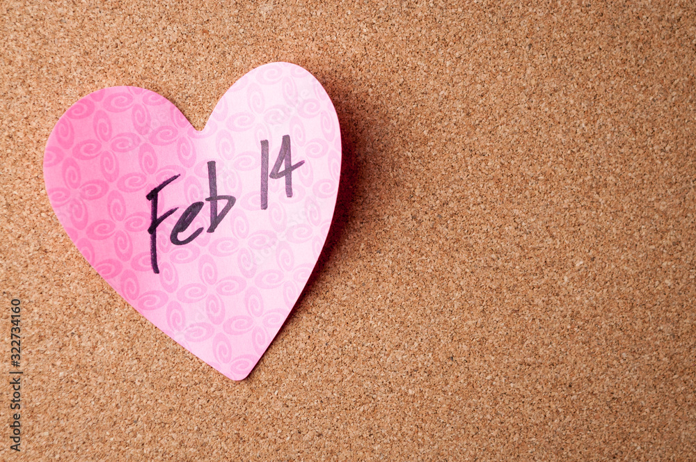 Handwritten reminder of Feb 14th Valentine's Day on pink heart with simple bulletin board copy space Handwritten reminder of Feb 14th Valentine's Day on pink heart with simple bulletin board copy space