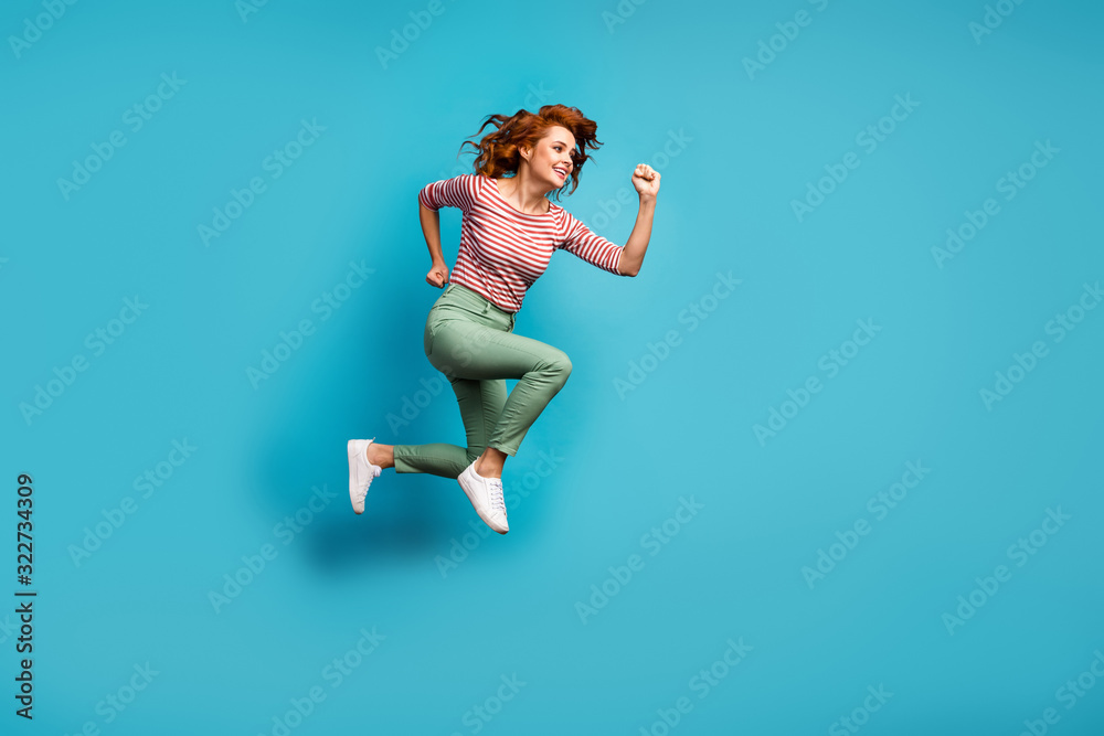 Full length profile photo of beautiful lady jump high active rushing final season shopping center wear casual red white shirt green trousers footwear isolated blue color background