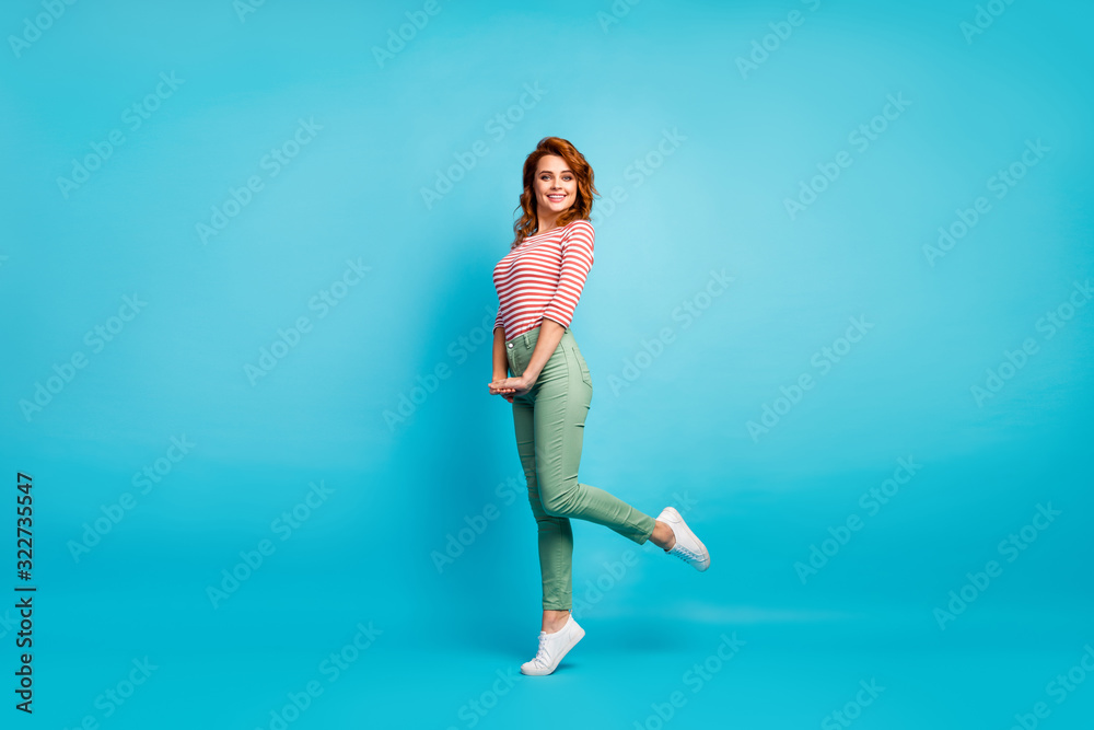 Obraz premium Full length profile photo of pretty lady enjoy warm spring day traveling abroad wear casual red white shirt green pants footwear isolated blue color background