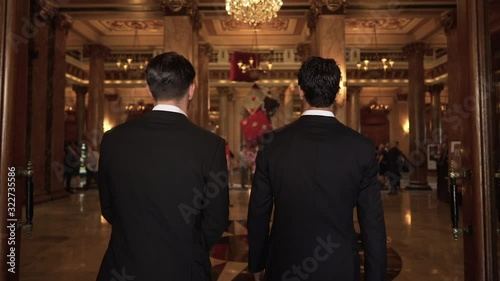 Epic slow motion shot of two men in suits entering casino hall in Monte Carlo, Monaco photo