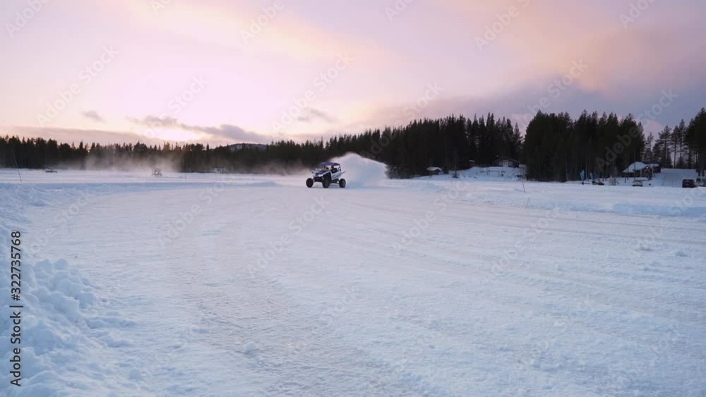 Slow motion of 4x4 Buggy drifting on snow track towards camera and spraying snow on the lens Slow motion of 4x4 Buggy drifting on snow track towards camera and spraying snow on the lens