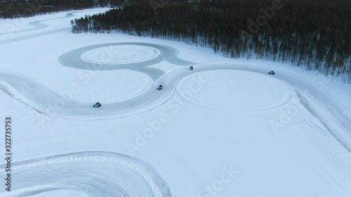 Aerial view of four buggys drifting along a curve on huge snow track photo