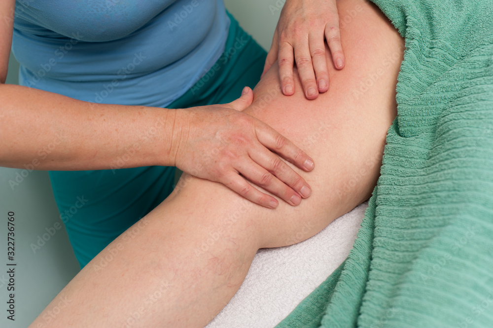 Woman massage the leg of a young unknown woman Woman massage the leg of a young unknown woman