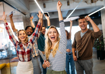 Happy business people celebrating success at company