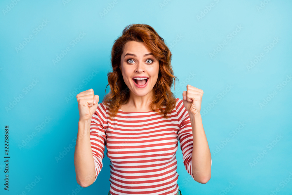 Fototapeta premium Portrait of ecstatic girl win desire wish lottery goal scream yeah raise fists wear good look outfit jumper isolated over blue color background