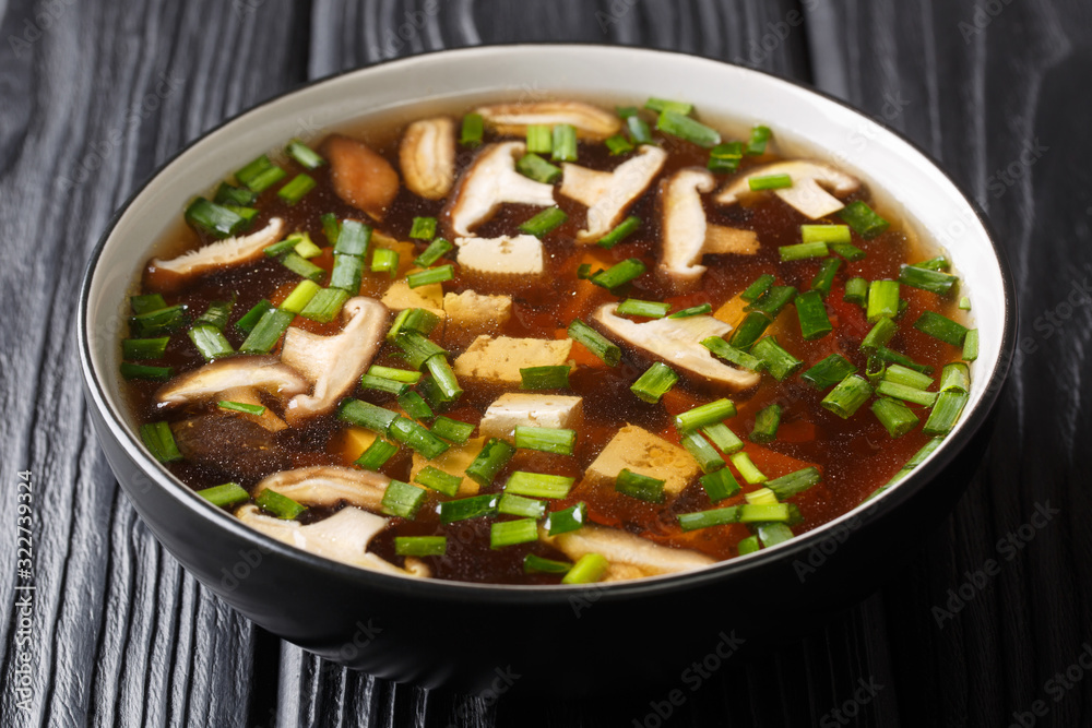 portion of Japanese soup with shiitake mushrooms, tofu and green onions close-up in a bowl. horizontal portion of Japanese soup with shiitake mushrooms, tofu and green onions close-up in a bowl. horizontal