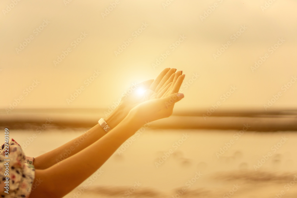 Young woman praying Hands  at sunset - obrazy, fototapety, plakaty 