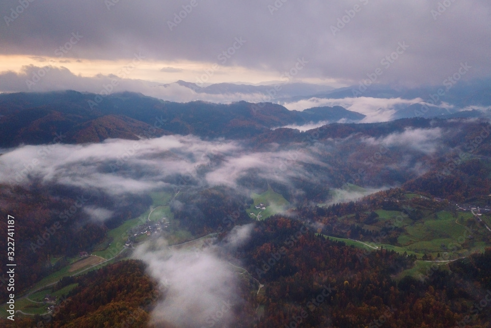 Beautiful misty sunrise over the alpine wooded mountain ridge, scenic landscape, aerial drone view, outdoor travel background, Alps mountains, Slovenia