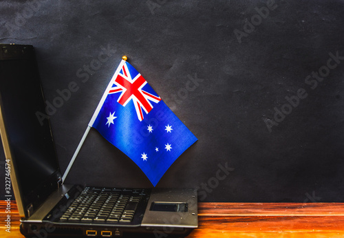  flag of Australia , computer, laptop on table and dark background