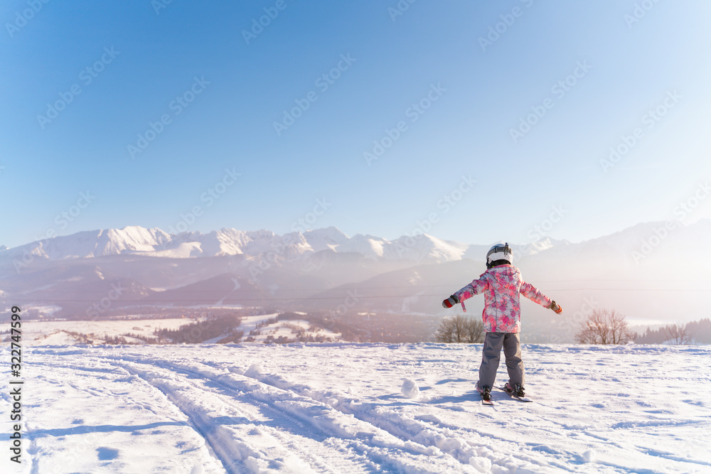 girl in outwear and masks with helmet skiing in the mountains in winter