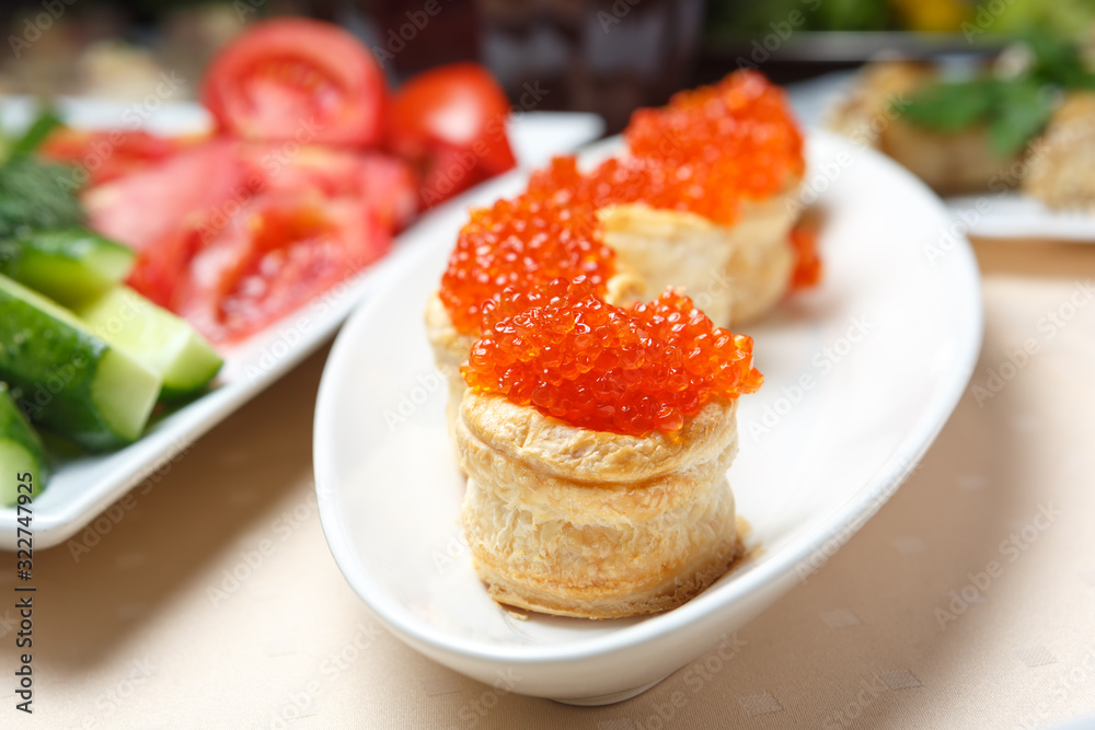 Red caviar on tartlets on a white plate