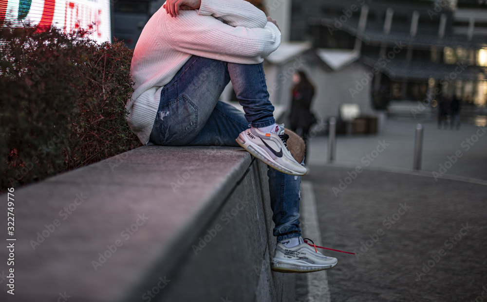 Young man wearing a pair of Nike Air Max 97 Off-White Photos | Adobe Stock