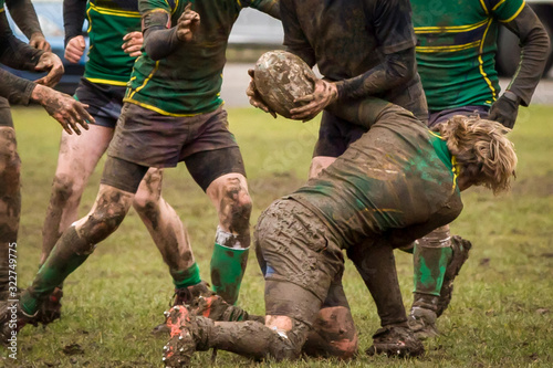 Dirty hands holding a rugby ball in a rugby game