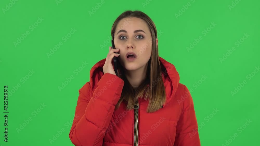Portrait of lovely girl in a red down jacket is talking for mobile phone. Green screen Portrait of lovely girl in a red down jacket is talking for mobile phone. Green screen
