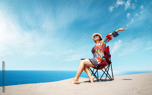 Beautiful sitting woman enjoying the idyllic scene of the sun, sand and sea. Beautyful sandy Patara beach in Antalya. 