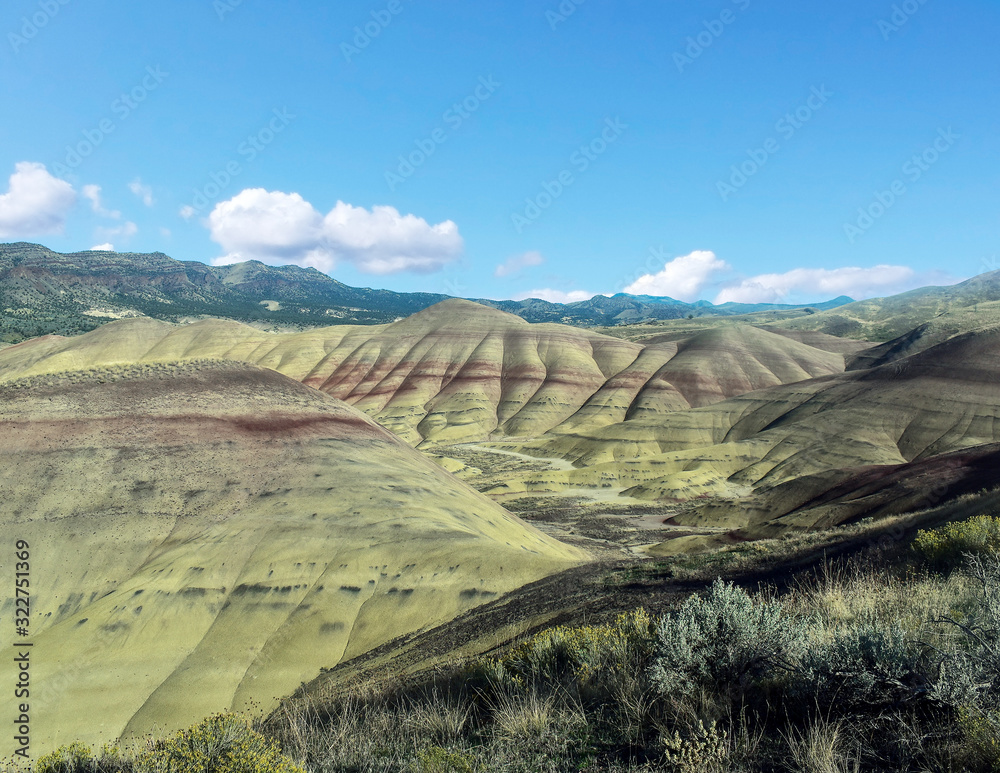 Breathing and colorful Painted Hills covered in red, tan, black, orange, and yellow stripes on a partly cloudy autumn day at the John Day Fossil Beds in Mitchell Oregon Breathing and colorful Painted Hills covered in red, tan, black, orange, and yellow stripes on a partly cloudy autumn day at the John Day Fossil Beds in Mitchell Oregon