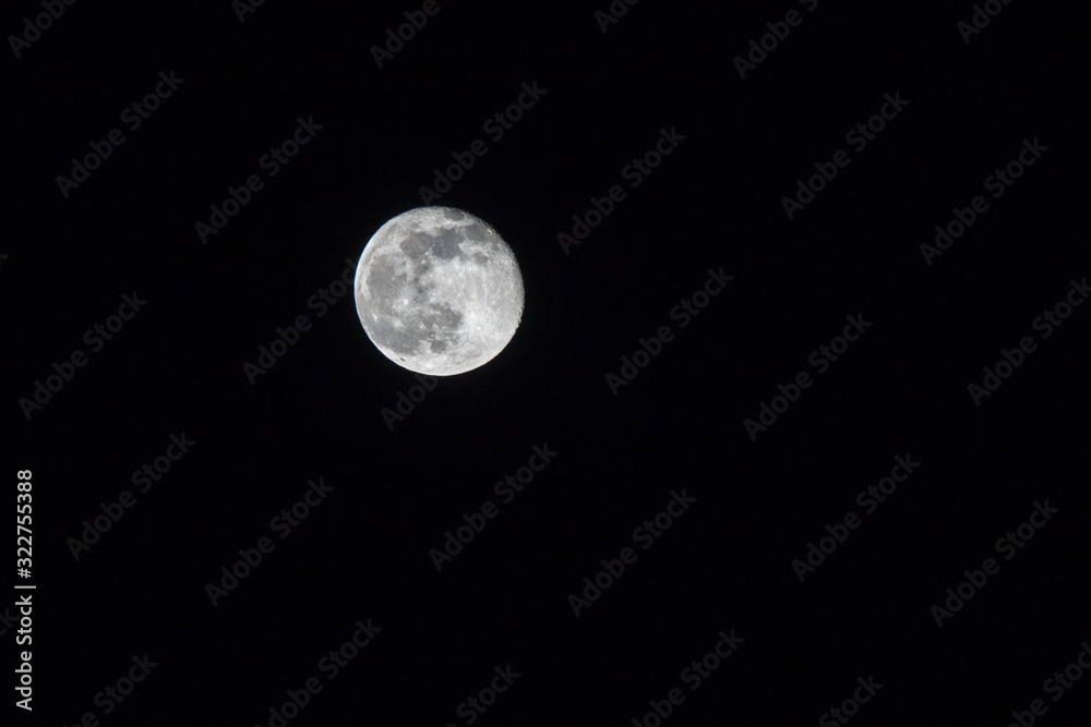 Full moon over dark black sky at night Full moon over dark black sky at night