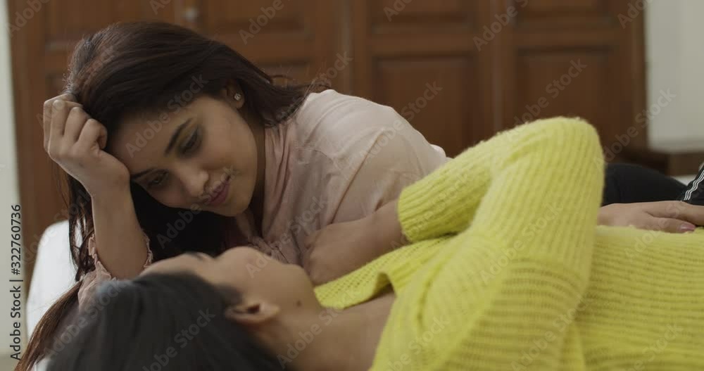 Young Indian couple lying around in their bed as they share soft and
