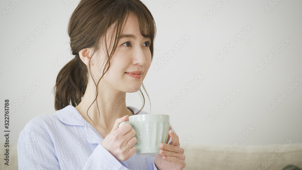 パジャマ姿でマグカップを持つ女性 パジャマ姿でマグカップを持つ女性